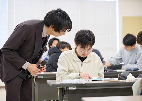 先生が丁寧に1人の学生に教えている様子