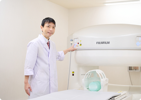 MRI装置の前で先生が立っている様子