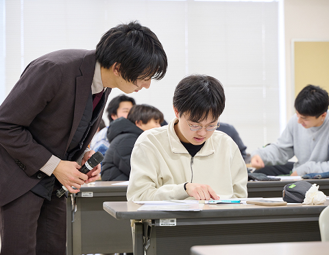 先生が1人の学生に丁寧に教えている様子