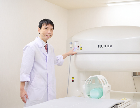 MRI装置の前で先生が立っている様子